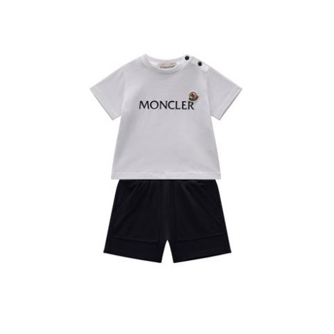 Completo di Moncler Kids, colore bianco e nero. Modello con t-shirt bianca, girocollo, maniche corte e scritta logo frontale. Bermuda corto colore nero. 