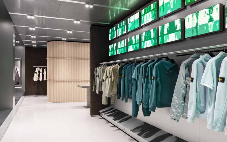Steel wall with green backlit display at the Stone Island store entrance