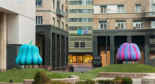 Louis Vuitton x Yayoi Kusama installation with black polka dots and mirrored spheres in a yellow space