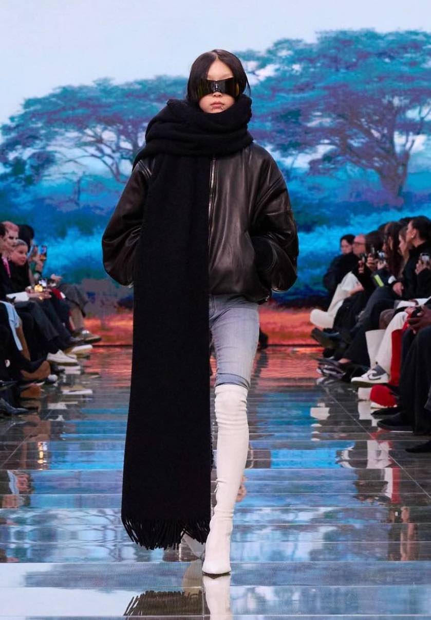 Modella Balenciaga tra gli schermi con paesaggi digitali
