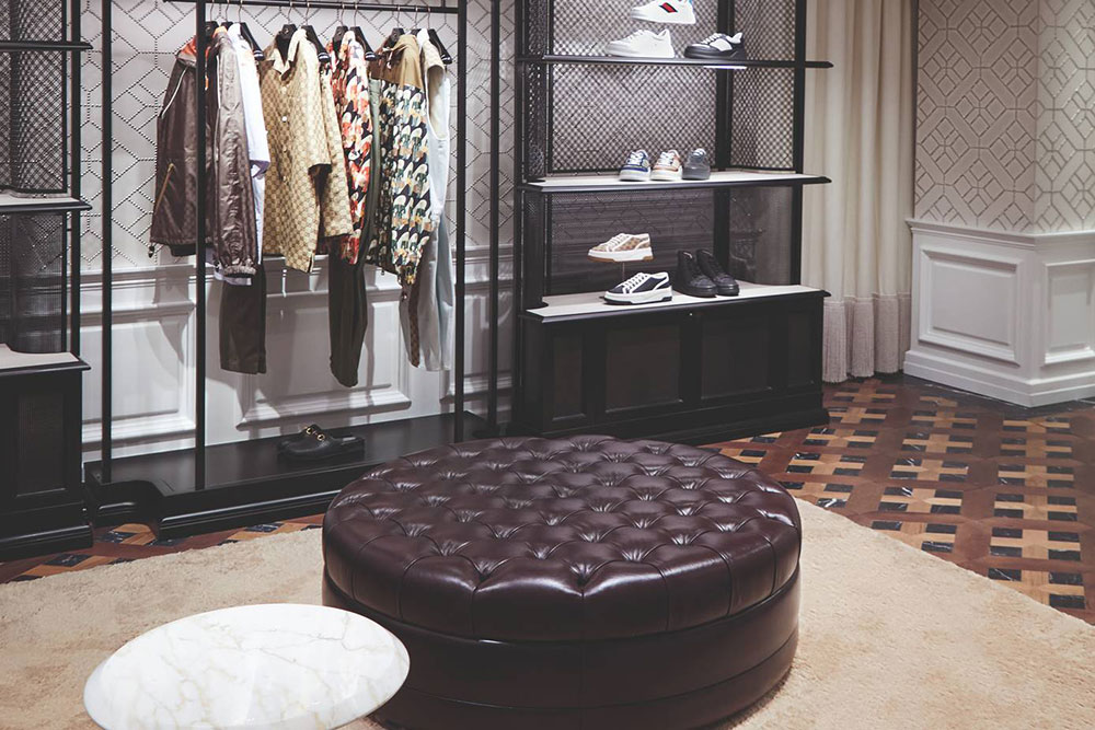 Gucci boutique room with inlaid wood flooring and leather sofas